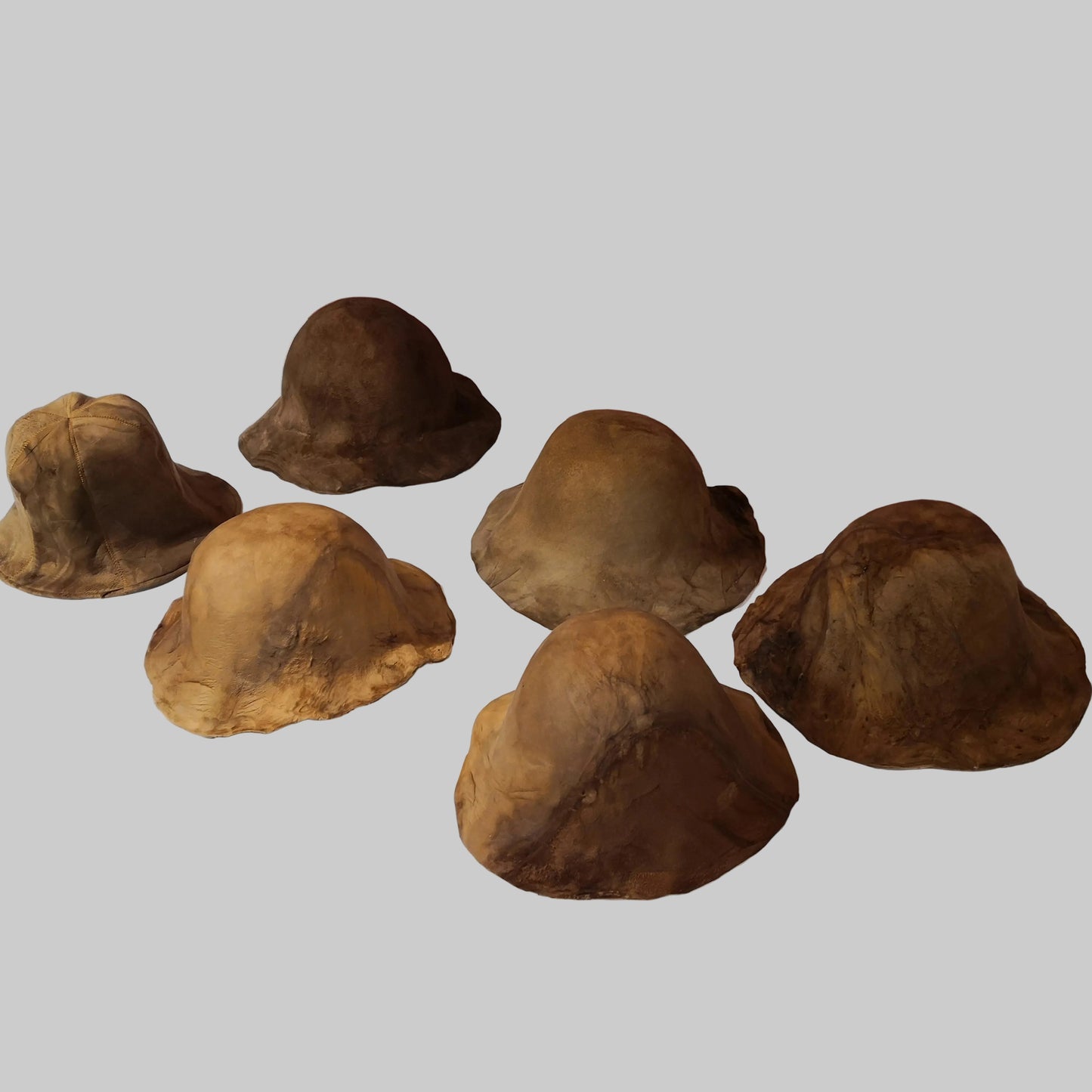 Set of brownamadou bucket hats on a white surface