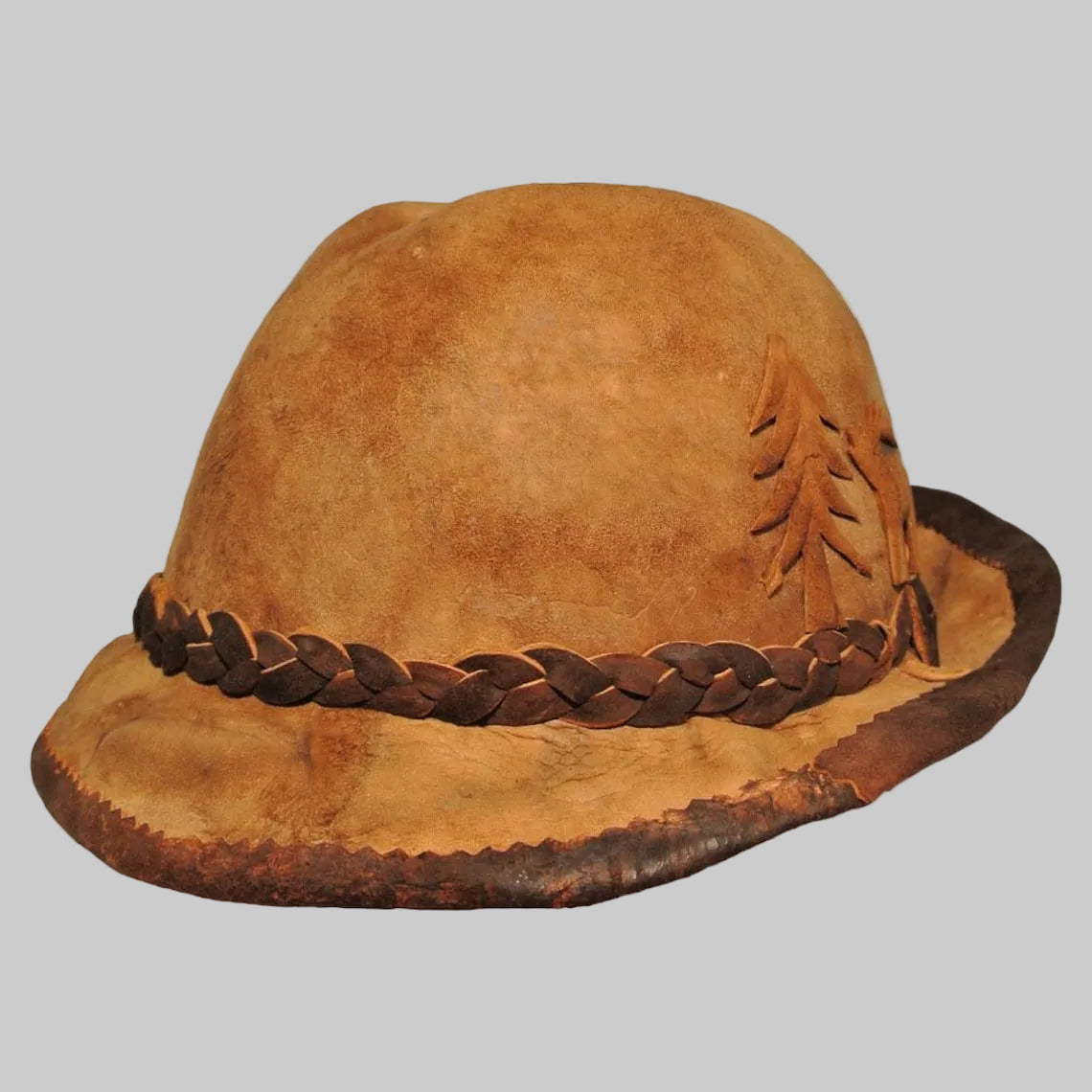 Brown amadou hat with braided band and tree design on a white background